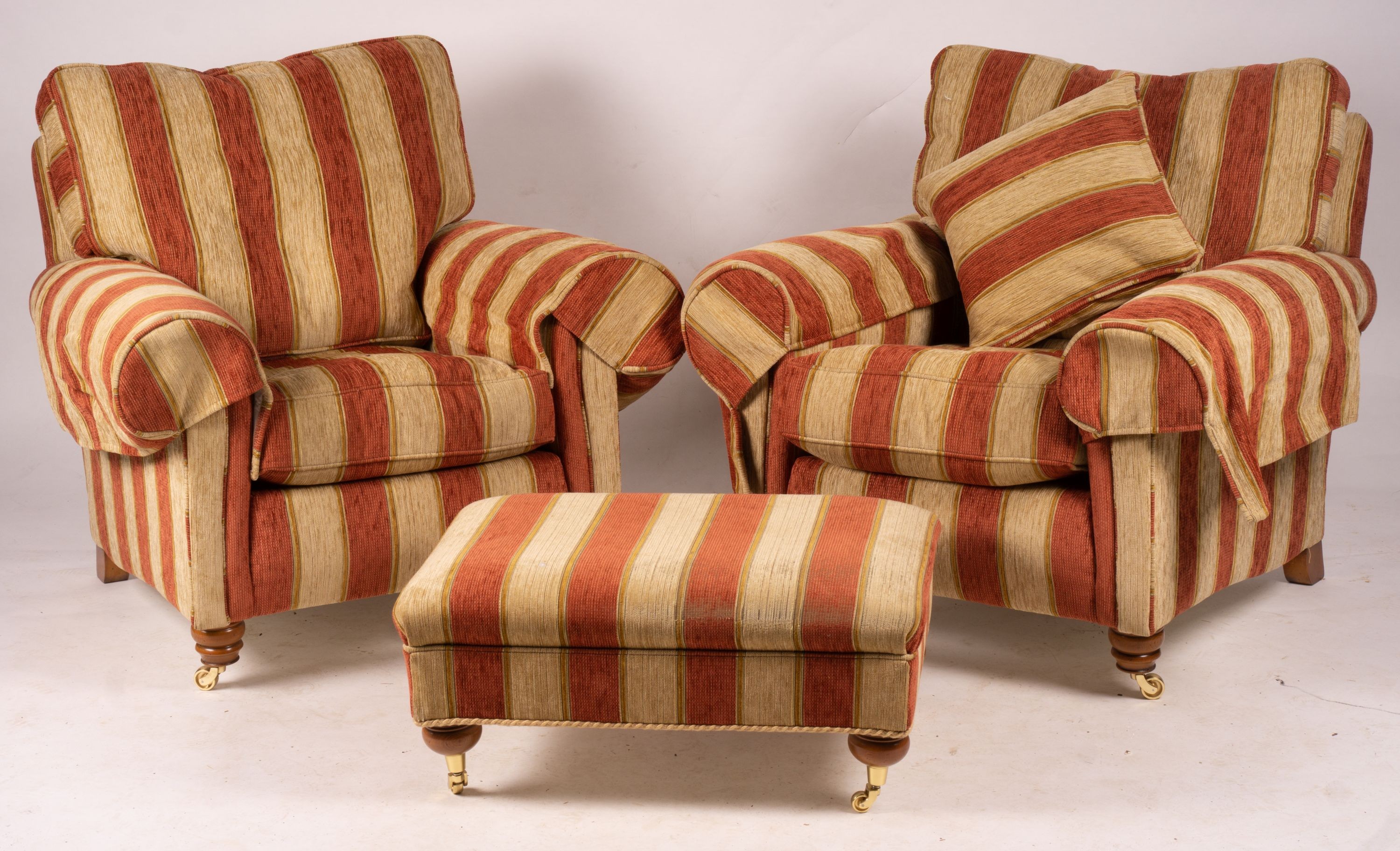 A pair of Duresta armchairs, width 94cm, depth 90cm, height 90cm and matching footstool in striped red and gold fabric